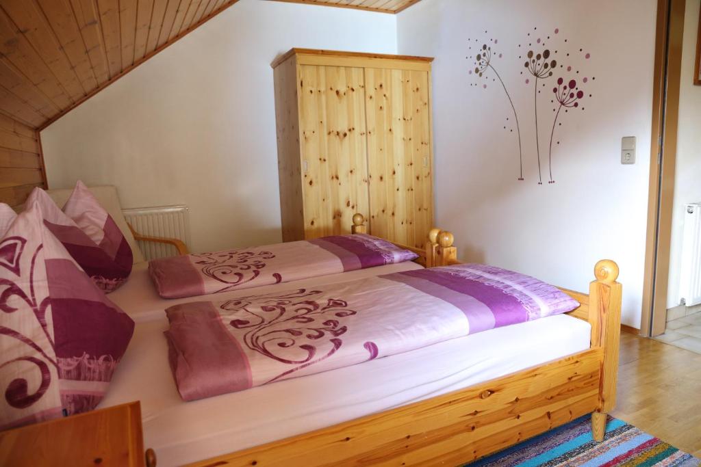 a bedroom with a large bed with a wooden headboard at Landhaus Unterköfler in Arriach