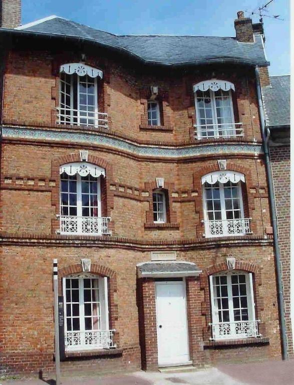 un ancien bâtiment en briques avec une porte et des fenêtres blanches dans l'établissement La Falaise, à Saint-Valery-sur-Somme