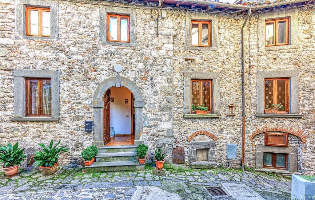 un antiguo edificio de piedra con una puerta y escaleras en Lovely Apartment In Gioviano -lu- With Kitchen, en Ghivizzano