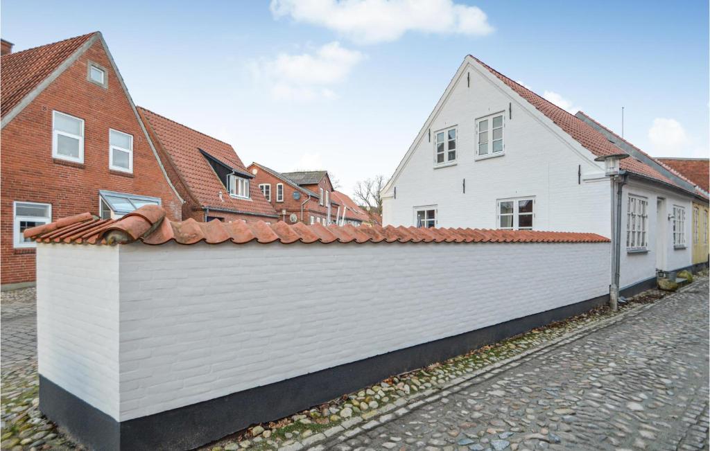 einen weißen Zaun vor einigen Häusern in der Unterkunft 3 Bedroom Cozy Home In Tnder in Tønder