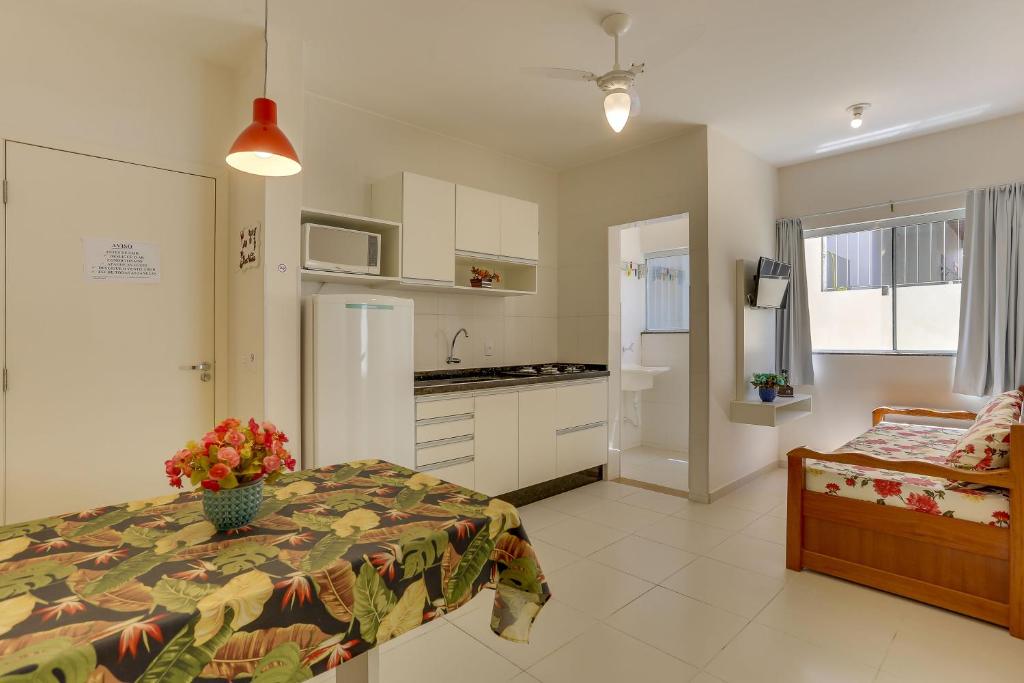 1 dormitorio pequeño con 1 cama y cocina en Lopes Residence 100 metros do mar Ingleses, en Florianópolis