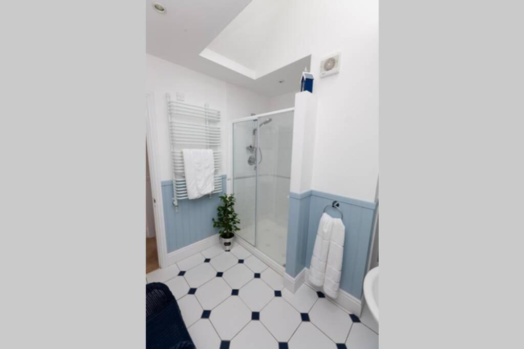 a bathroom with a shower and a tiled floor at RED LION LOFT BLIDWORTH in Blidworth