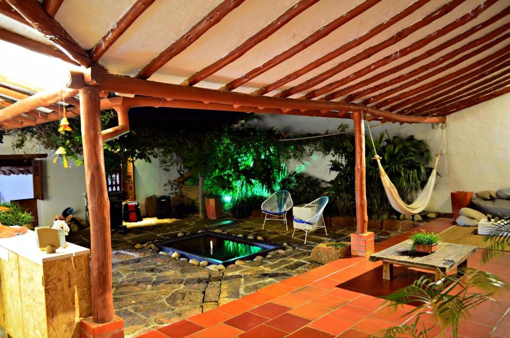 un patio con piscina y pérgola de madera en La Casa de Hercilia Boutique, en Barichara