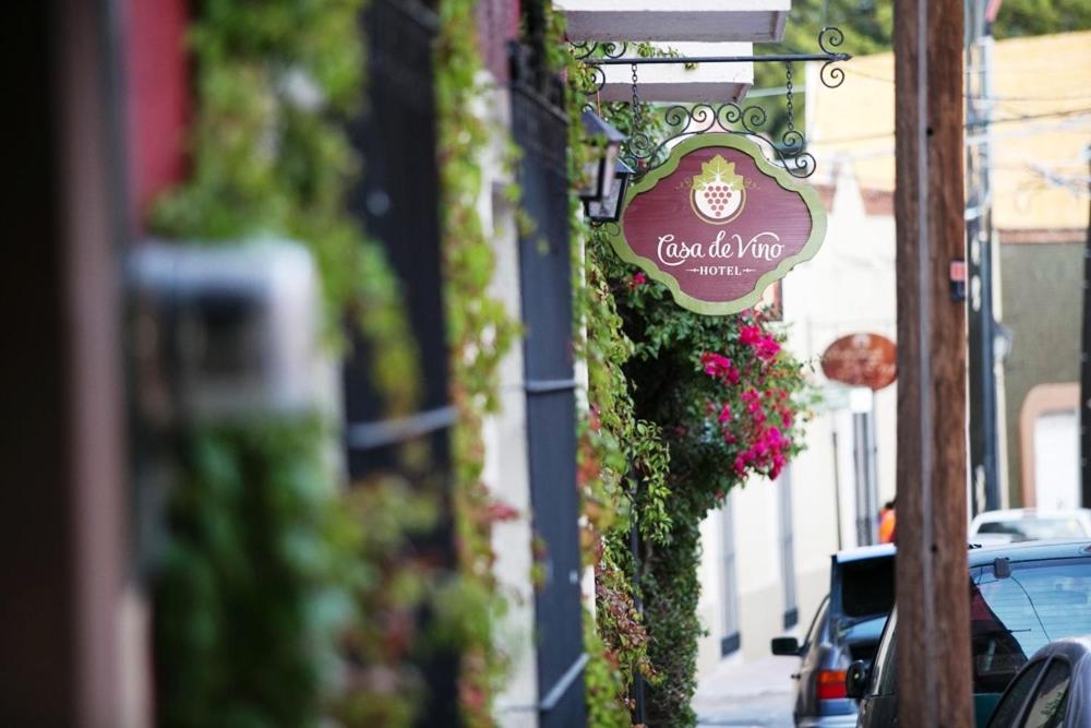 a sign on the side of a building with flowers at Hotel Casa de Vino in Tequisquiapan