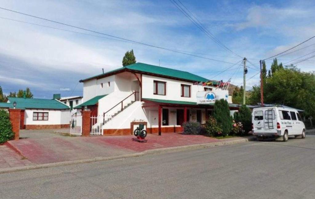 una furgoneta blanca estacionada frente a un edificio en Los Dos Pinos en El Calafate