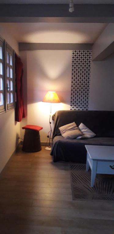 ein Schlafzimmer mit einem Bett mit einer Lampe und einem Tisch in der Unterkunft Appartement 1 er Etage , St Goustan Port Auray in Auray