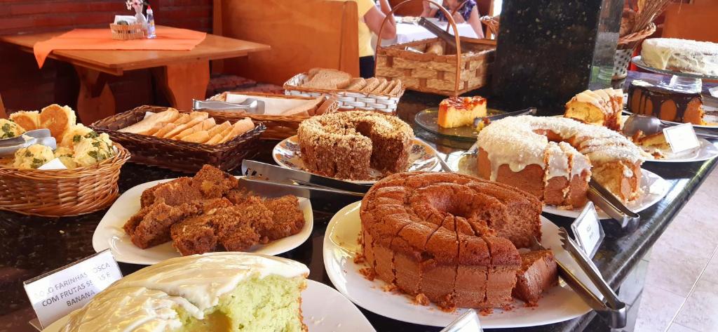 a display of different types of cakes and pastries at Hotel Serra Everest in Nova Friburgo