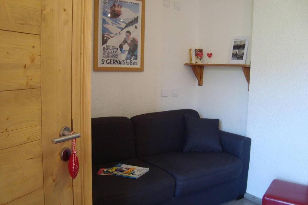 a blue couch in a room with a poster on the wall at val thorens appartement 4 personnes ski aux pieds in Val Thorens