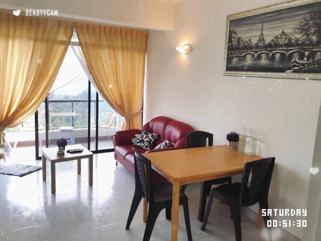 sala de estar con mesa y sofá rojo en Berjaya Hills Sweet Homestay, en Tok Tok