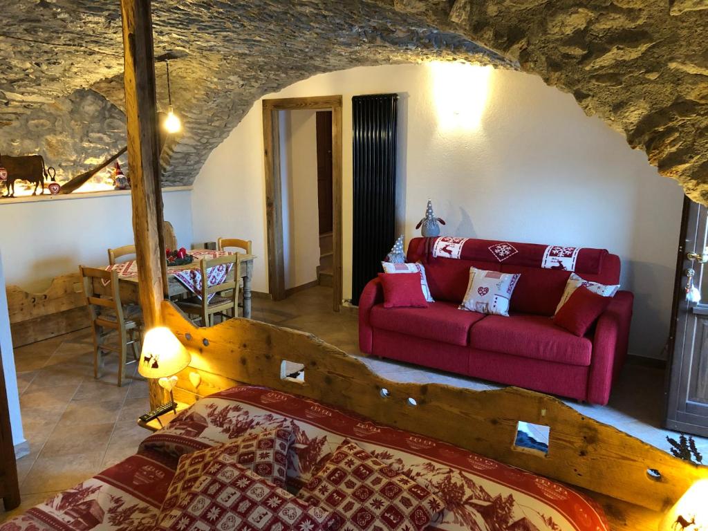 ein Wohnzimmer mit einem Bett und einem Sofa in der Unterkunft Maison Lucien in Gignod