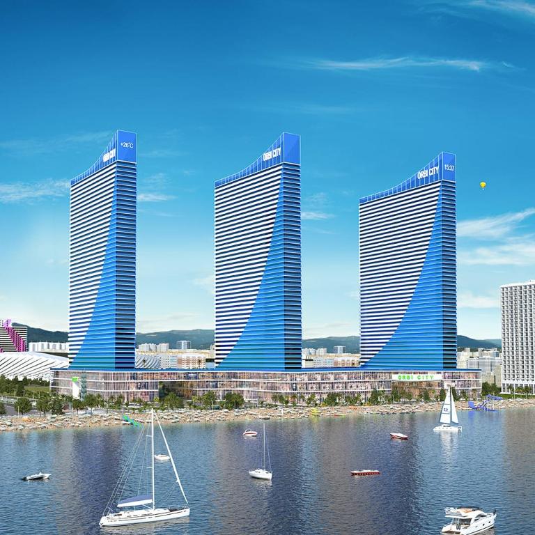 a group of tall buildings with boats in the water at Apartment Twin Towers David in Batumi