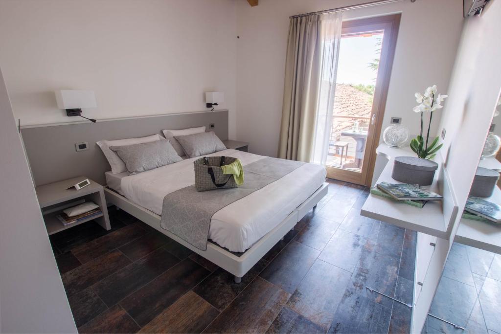 um quarto branco com uma cama e uma janela em Casanova Inn em Martignacco
