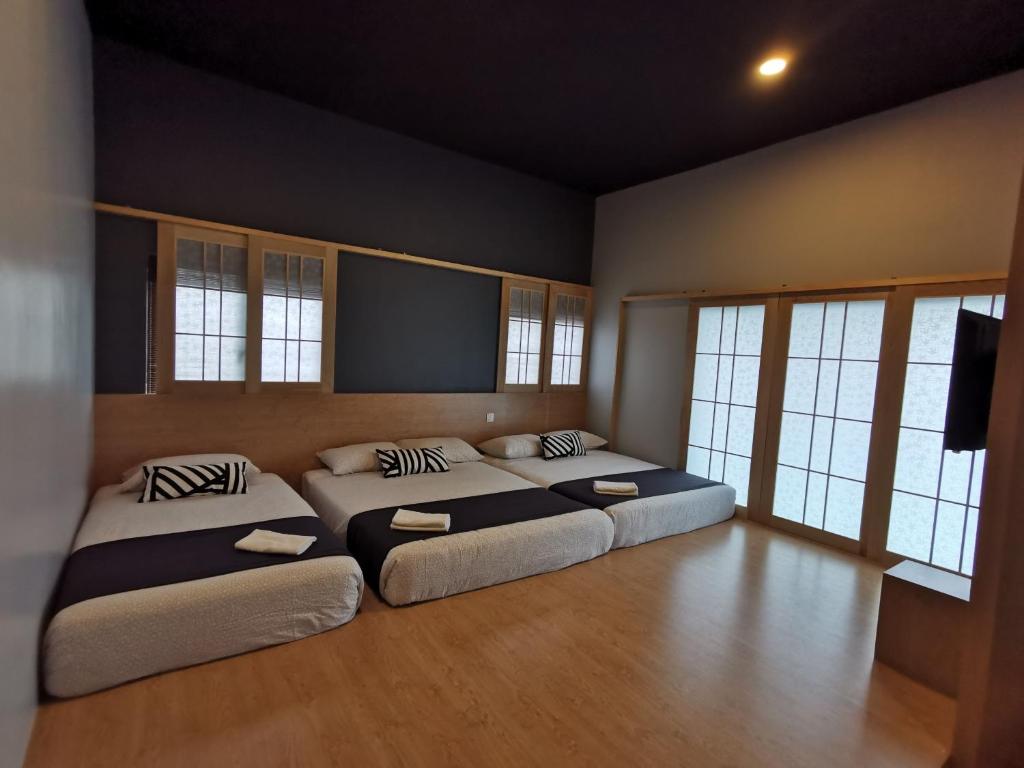 a bedroom with two beds and a flat screen tv at Tatami D'Tepi Laut - PANGKOR ISLAND in Pangkor