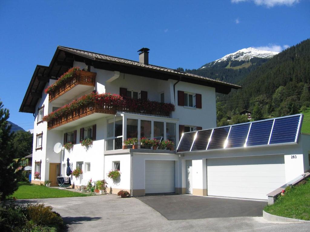 a white house with solar panels on it at Ferienhaus Lerch in Sankt Gallenkirch