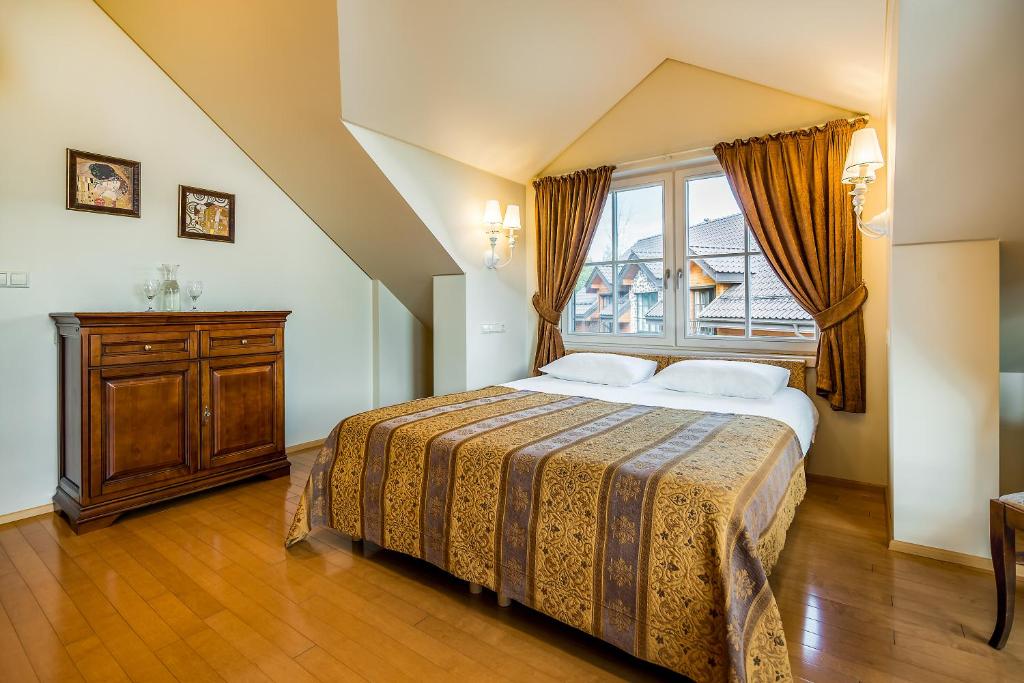 een slaapkamer met een groot bed en een raam bij Villa Avirio Vingis in Druskininkai