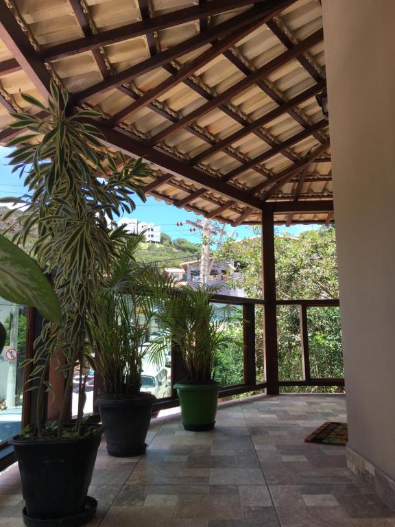 a patio with potted plants and a wooden ceiling at Varandas do Atalaia Suítes in Arraial do Cabo