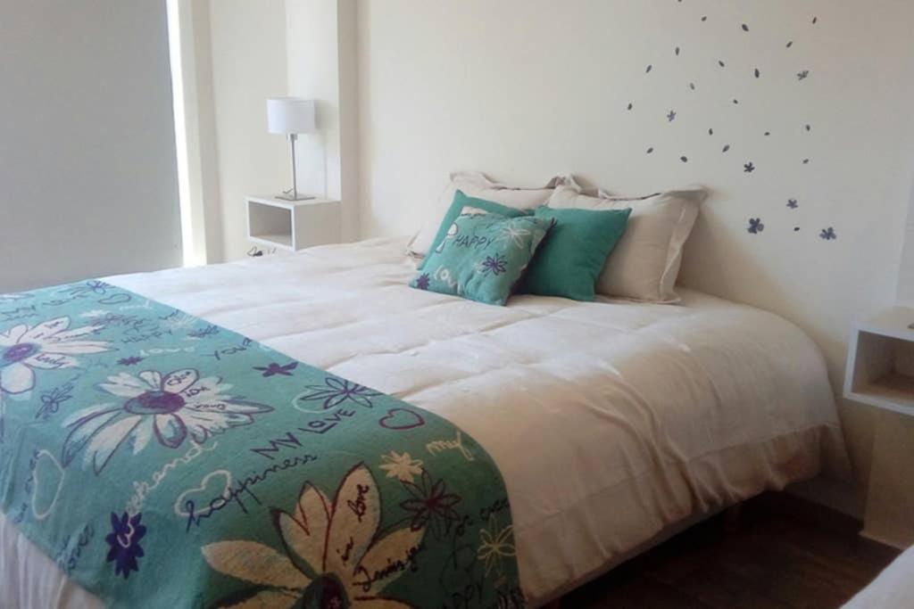 ein Schlafzimmer mit einem großen Bett mit einer Blumenbettdecke in der Unterkunft Brc Apartment in San Carlos de Bariloche