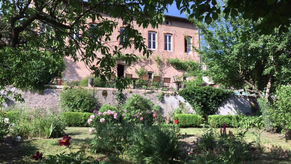 a garden in front of a large brick building at la grange aux oiseaux in Arnaville