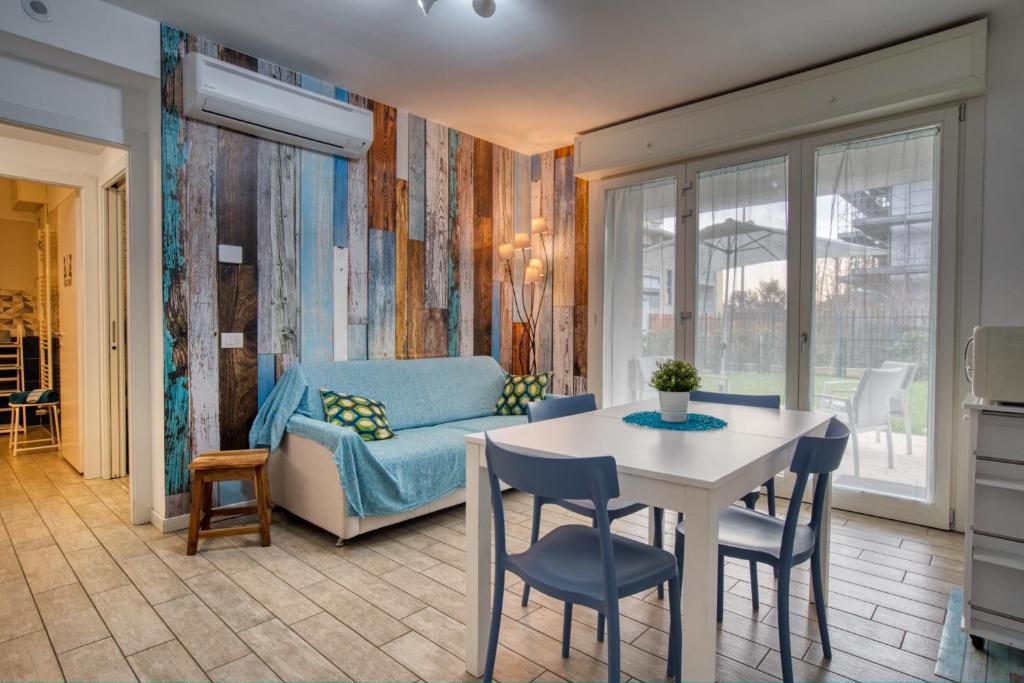 un soggiorno con tavolo e divano di CaseOspitali - CASA AZZURRA incantevole bilocale con giardino a Cernusco sul Naviglio