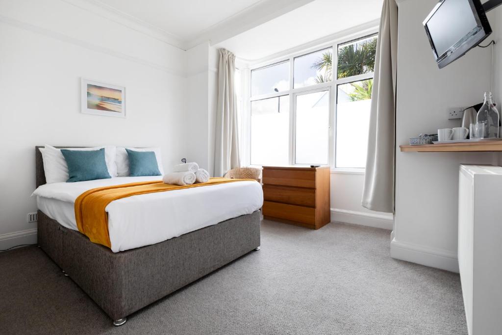 Un dormitorio con una cama grande y una ventana en Oasis House, en Falmouth