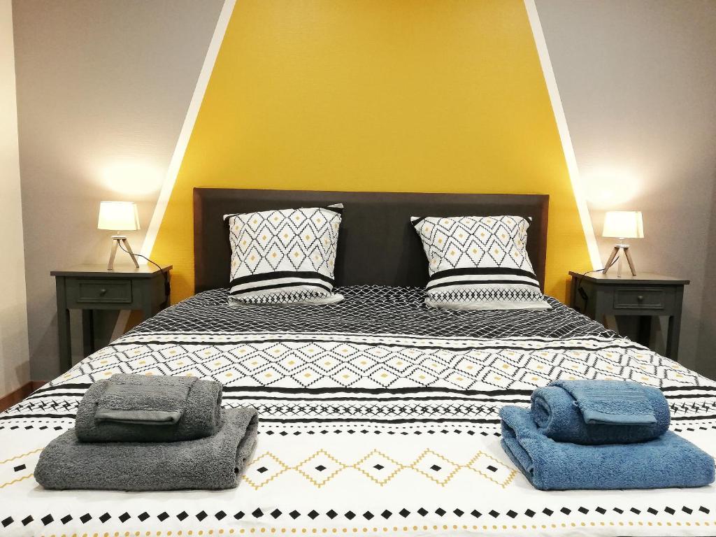 une chambre avec un grand lit avec deux oreillers dessus dans l'établissement LUCKY PLACE - PARKING - CENTRE - BALCON, à Colmar