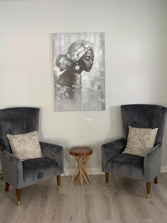 two chairs and a table in a room with a picture at LA RÉVERIE in Franschhoek