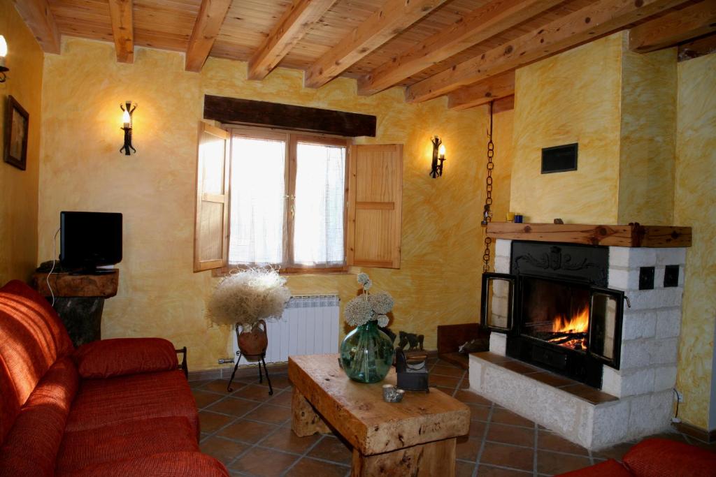 sala de estar con sofá y chimenea en Casa Rural Roblejimeno, en Cubillo del César