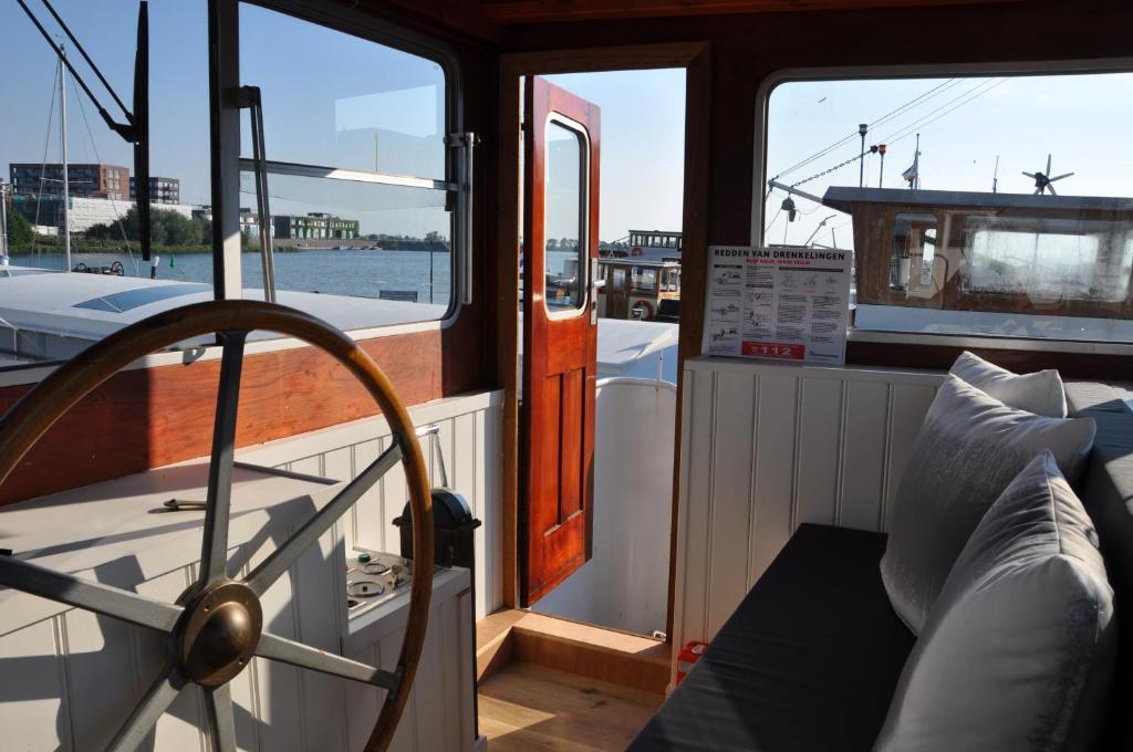 a boat with its door open on the water at Private Lodge on Houseboat Amsterdam in Amsterdam