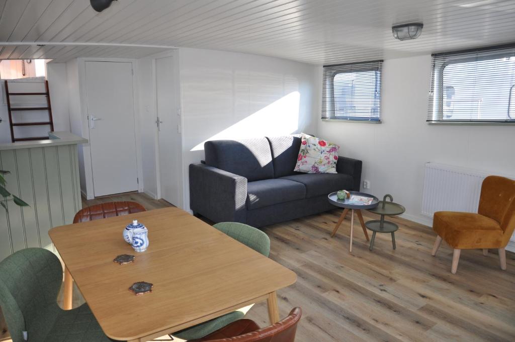 a living room with a table and a couch at Private Lodge on Houseboat Amsterdam in Amsterdam