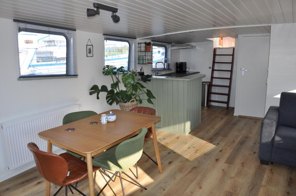 a dining room and kitchen in a tiny house at Private Lodge on Houseboat Amsterdam in Amsterdam