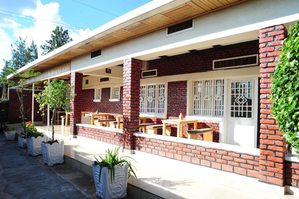 a brick building with tables and chairs on it at INZOZI AFRICA HOUSE B&B- Kacyiru in Kigali