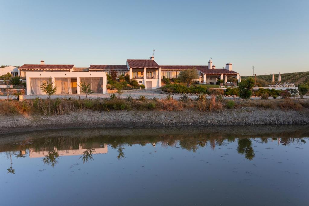 uma casa com um lago em frente em Monte da Estrela - Country House & SPA em Mourão