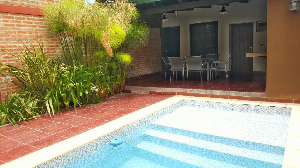 una piscina junto a un patio con mesa y sillas en Carnaval p/6 - 2 dorm - Amplio y a 5' del centro en Salta