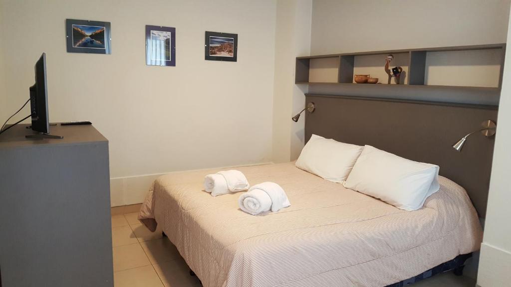 1 dormitorio con 1 cama con toallas en Pachamama - Depto p/4 nuevo y a 5' del centro en Salta
