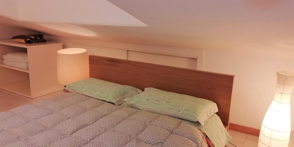 sypialnia z łóżkiem z drewnianym zagłówkiem w obiekcie L'Alloggio di Anna Maria Mansarda con bagno privato w mieście Empoli