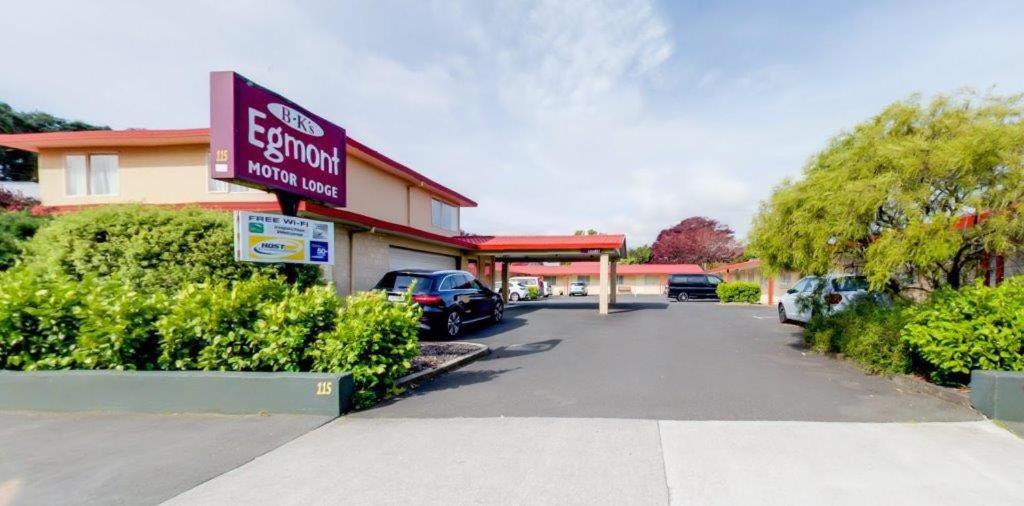 een tankstation met een bord op een parkeerplaats bij Bks Egmont Motor Lodge in New Plymouth