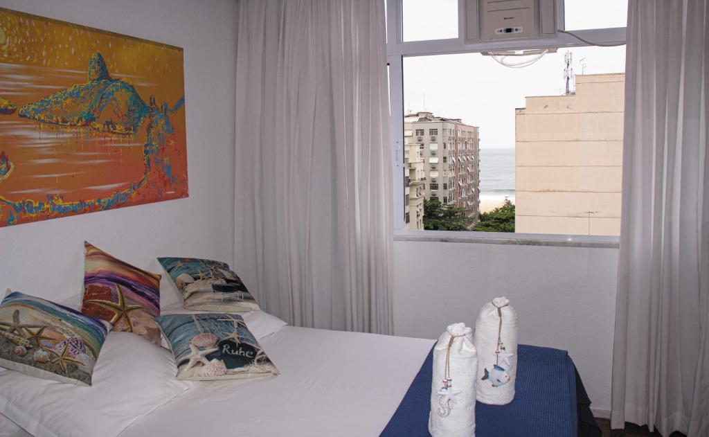 a bedroom with a bed and a window with a view at Apartamento de Férias Copacabana Rio de Janeiro in Rio de Janeiro