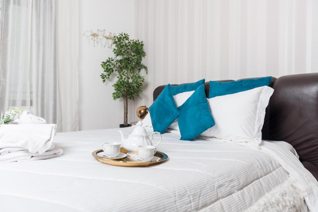 taca z kubkami i spodkami na łóżku w obiekcie Suite room w mieście Aversa