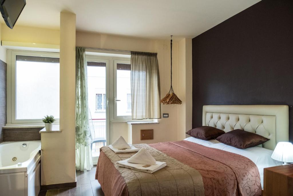 1 dormitorio con 1 cama grande y bañera en Aida Charming Rooms, en Roma