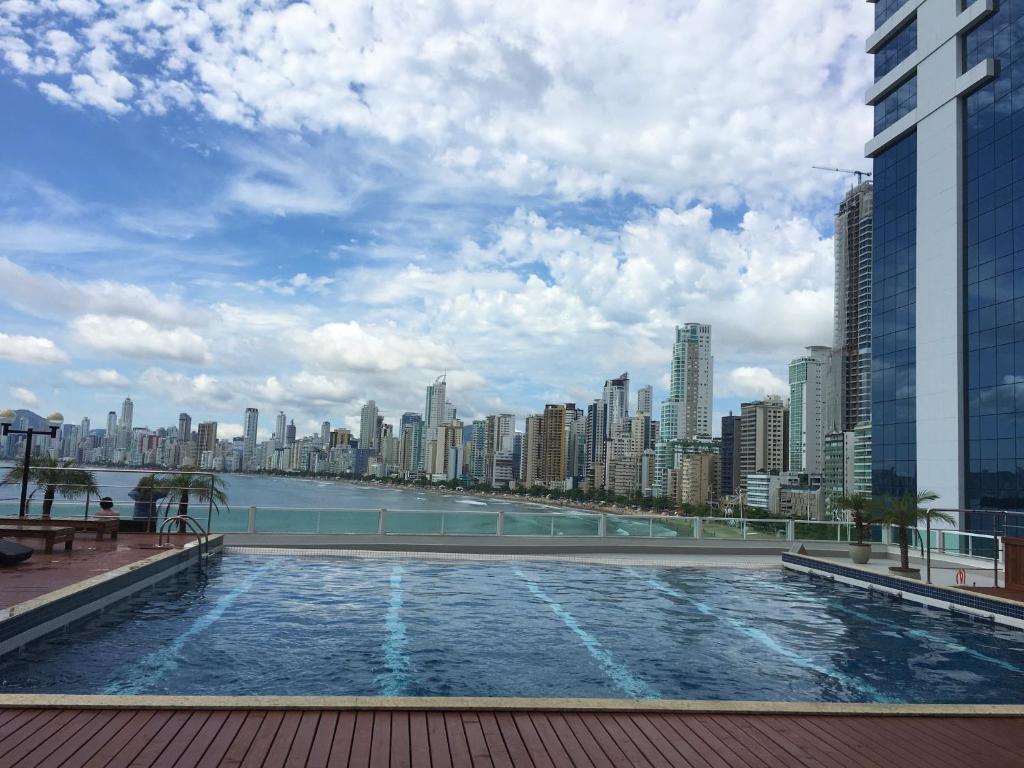 a swimming pool on the roof of a building with a city at APARTAMENTO FRENTE MAR com vista fantástica in Balneário Camboriú