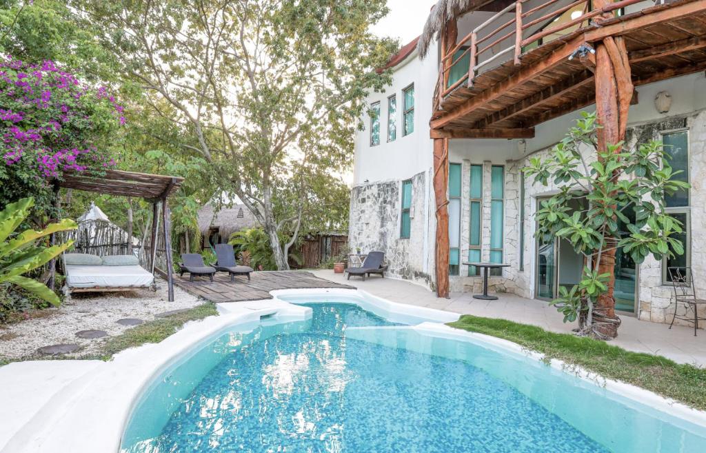 a swimming pool with a balcony overlooking a beach at Harmony Glamping Boutique Hotel and Yoga in Tulum