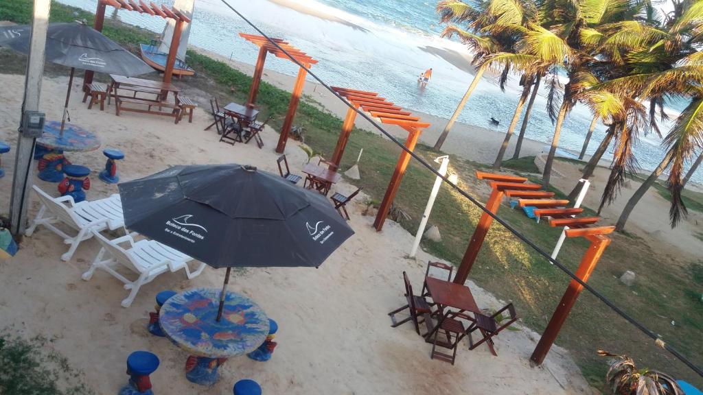 - une vue sur la plage dotée de chaises et d'un parasol dans l'établissement Pousada Recanto das Fontes, à Beberibe