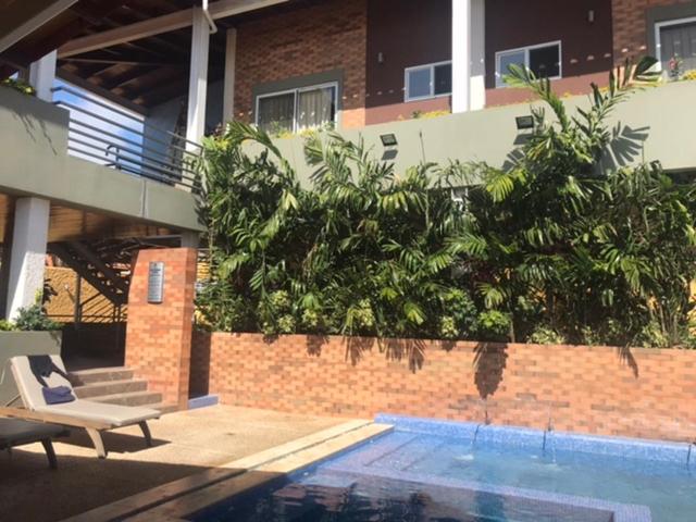 a house with a pool and a chair next to a building at Brisas de San Lorenzo Posada Lounge in Porlamar