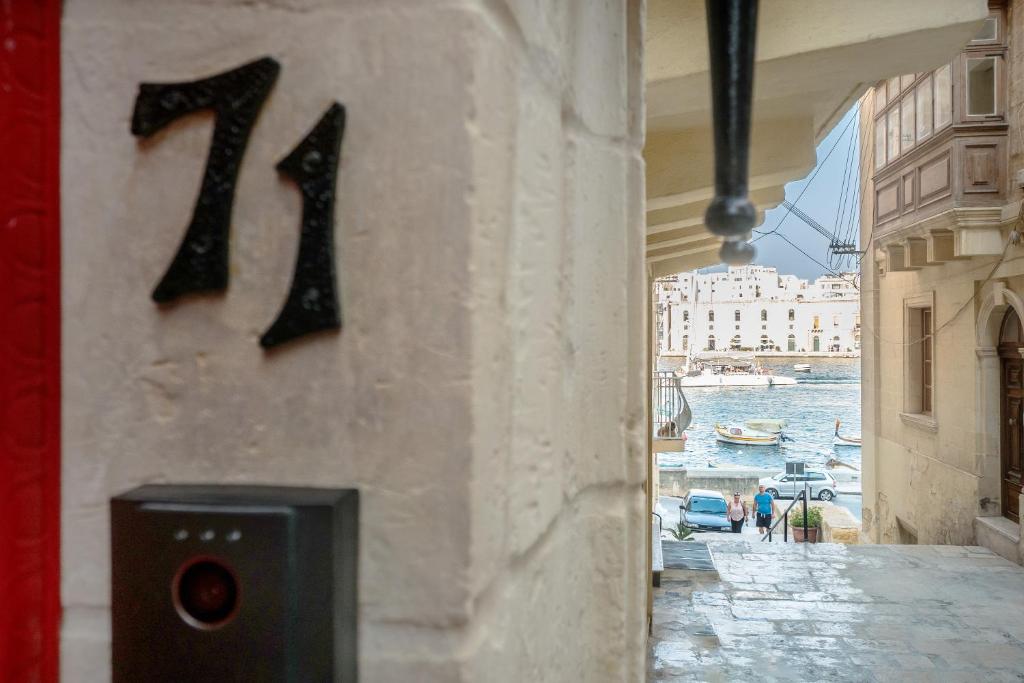a number on the side of a building next to a canal at Entire House of Character - Castelinho Sao Marcos in Senglea