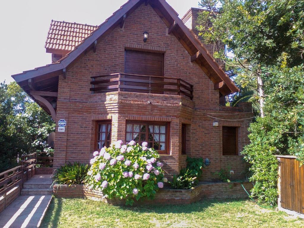 una casa de ladrillo con un arbusto de flores delante de ella en Cabaña Ostende en Ostende