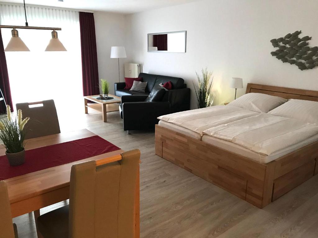 um quarto com uma cama e uma sala de estar em Steiner Strandappartements Appartement 307 Süd- Landseite em Stein