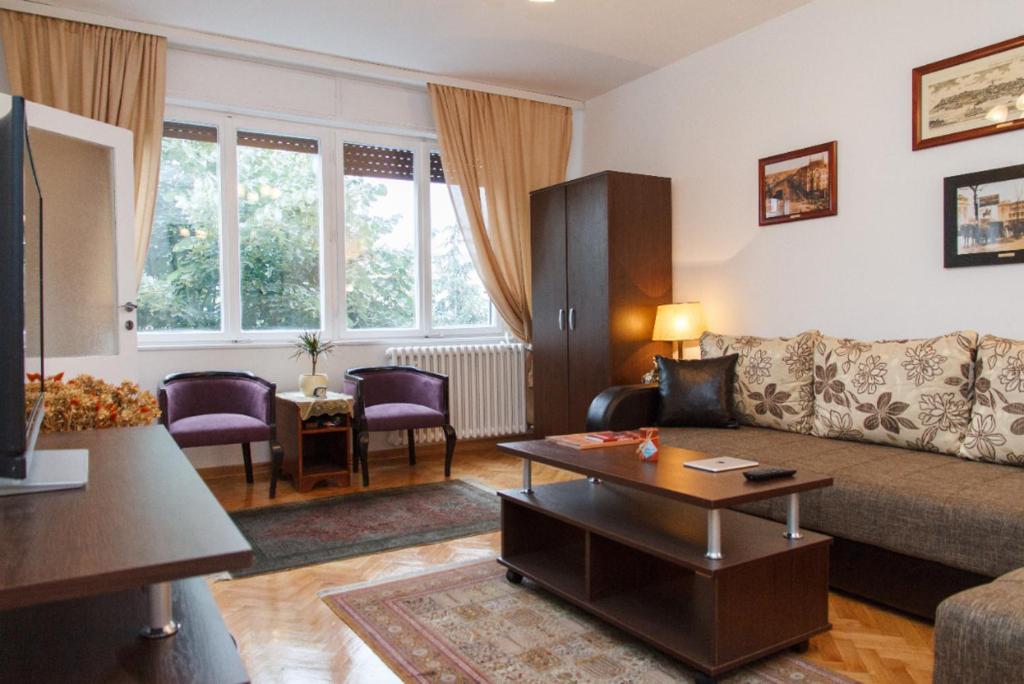 ein Wohnzimmer mit Sofa und Tisch in der Unterkunft Modern Cozy Apartment in Belgrad