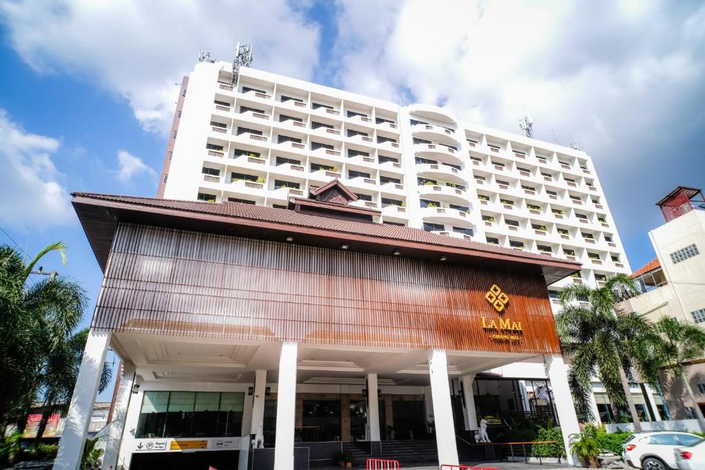 un gran hotel blanco con un edificio detrás de él en La Mai Hotel, en Chiang Mai