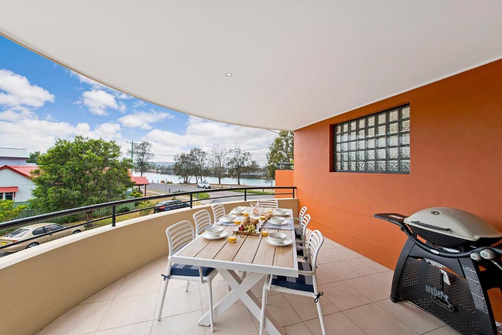 a table and chairs on a balcony with a scooter at Adrift at Dolphin Cove Apt 5 - riverfront modern in North Haven