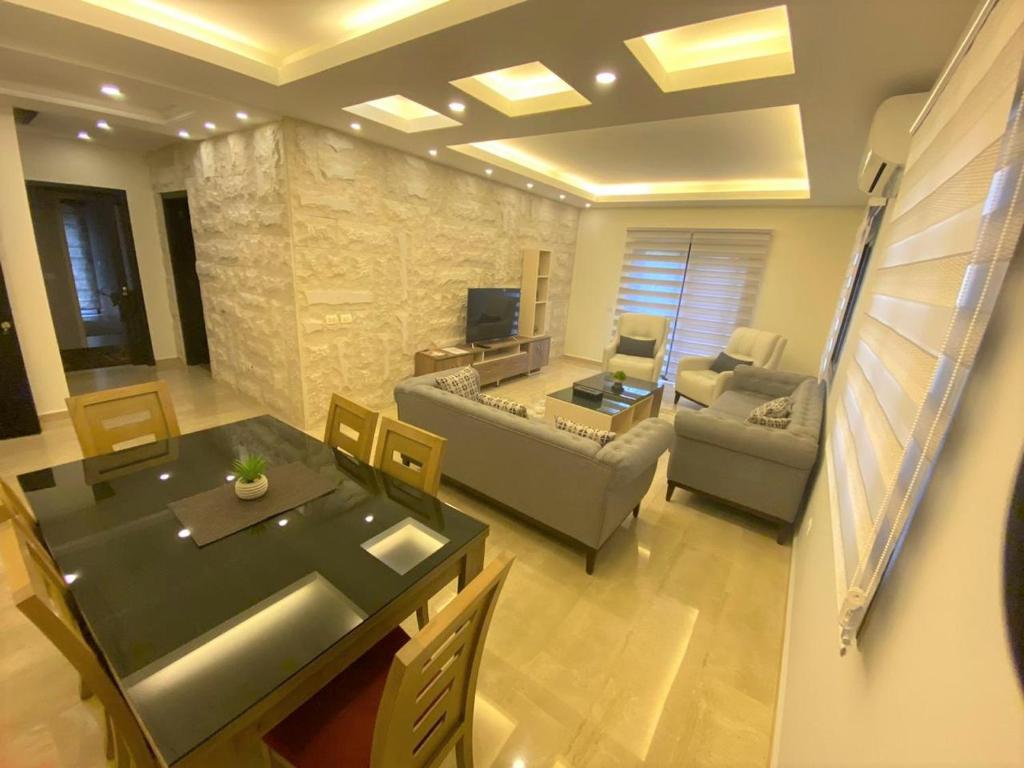 een woonkamer met een bank en een tafel bij Elite Residence - Furnished Apartments in An Nakhlah